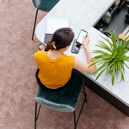 Young woman checking phone instead of doing work