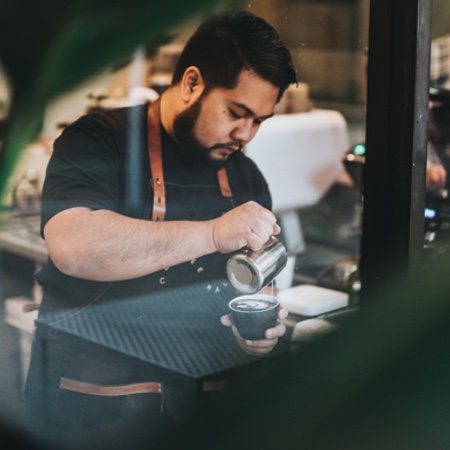 Young man pouring an espresso