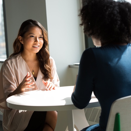 Human resources professional interviewing a candidate at a table